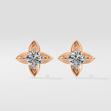 Pair of rose gold diamond earrings with clear gemstones on a light gray background
