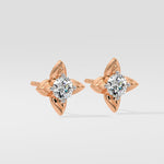 Rose gold diamond earrings with diamond-like stones on a light gray background
