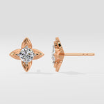 Rose gold diamond stud earrings on a light gray background