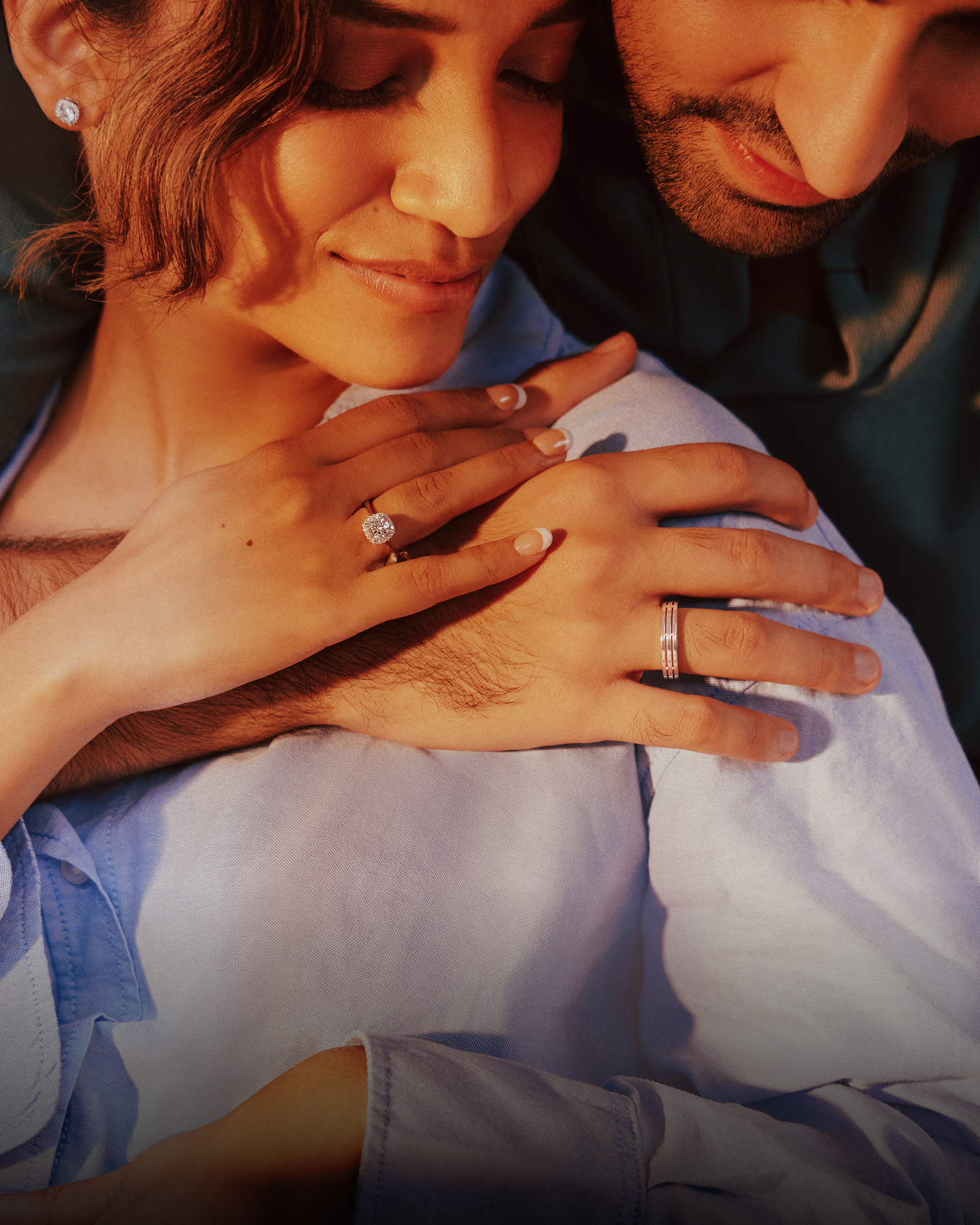 A couple with hands interlocked, close-up of their fingers wearing lab-grown diamond rings.