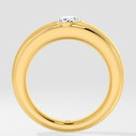 Gold ring with a lab grown diamond on a light gray background