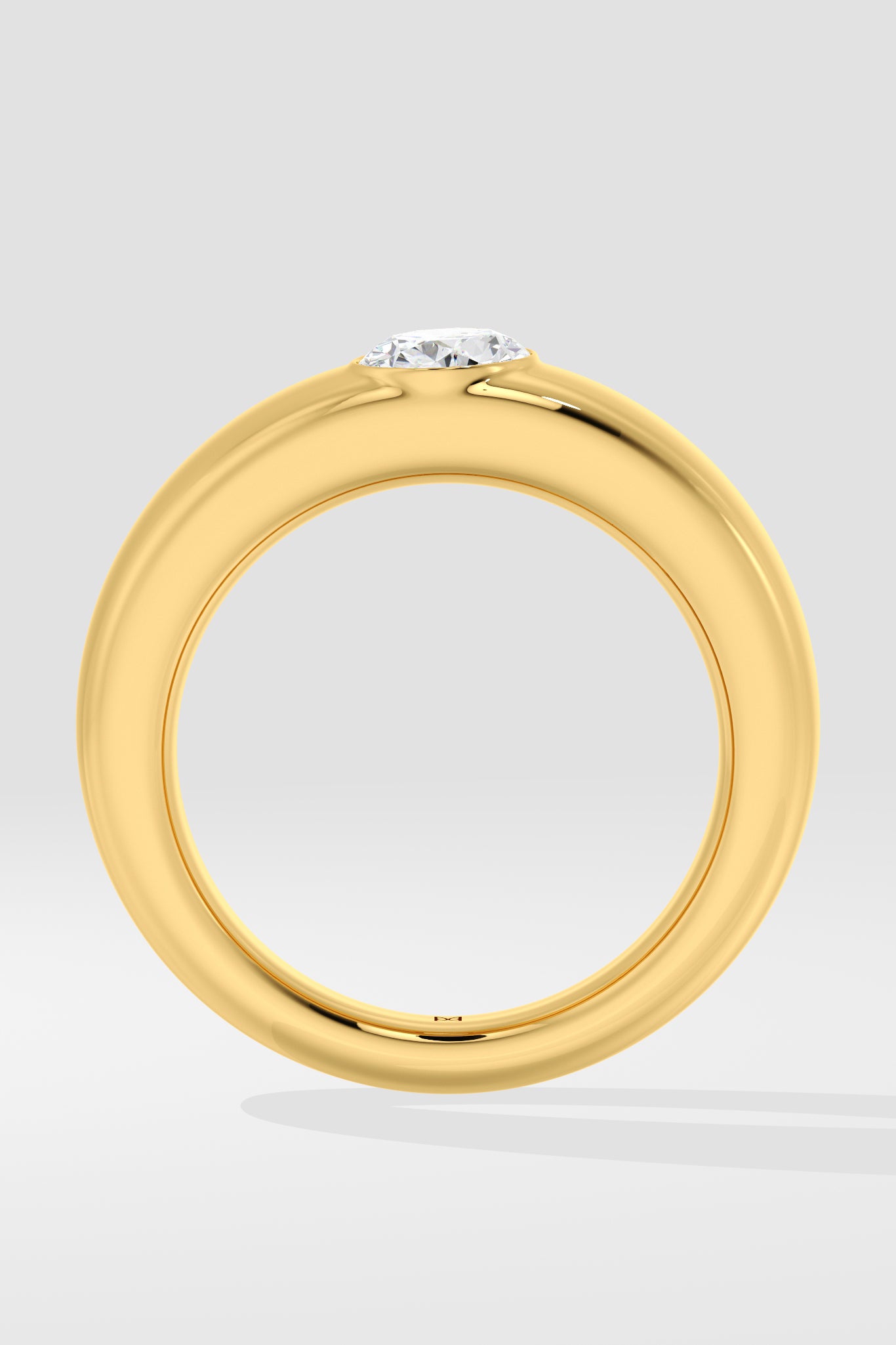 Gold ring with a lab grown diamond on a light gray background
