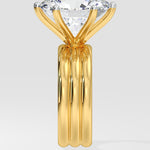 Gold diamond ring with a large diamond on a light gray background