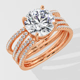 Rose gold ring with a large lab grown diamond and smaller diamonds on the band against a light gray background