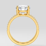 Gold ring with a large central gemstone on a light gray background