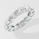 Silver diamond band ring with oval diamond on a light gray background