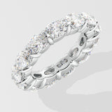 Silver diamond band ring with oval diamond on a light gray background