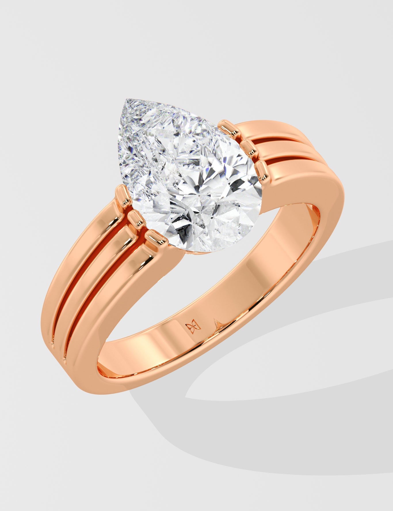 Rose gold pear diamond ring on a light gray background