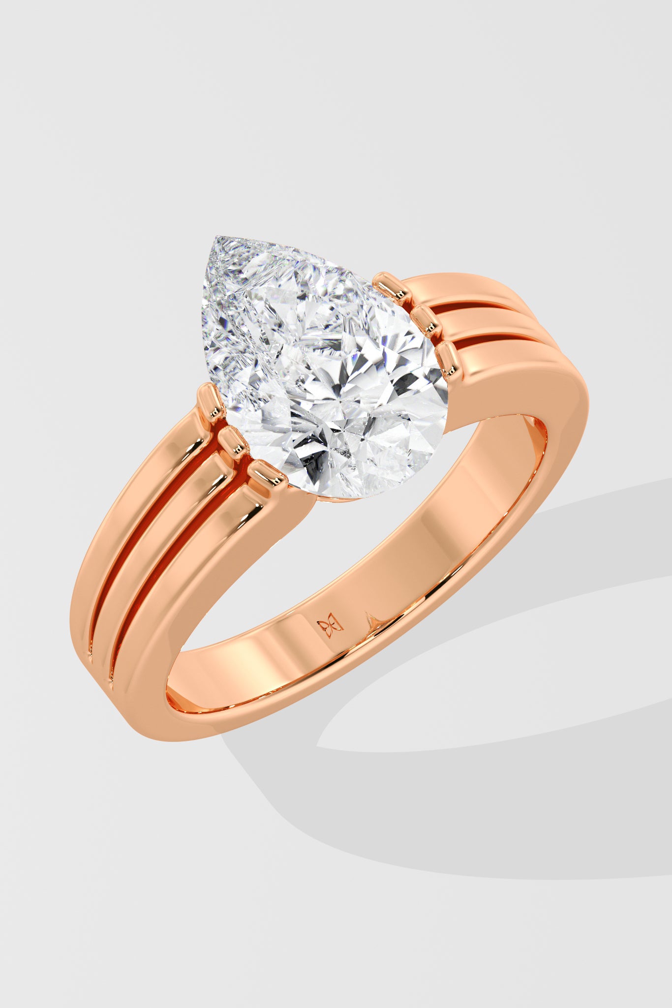 Rose gold pear diamond ring on a light gray background