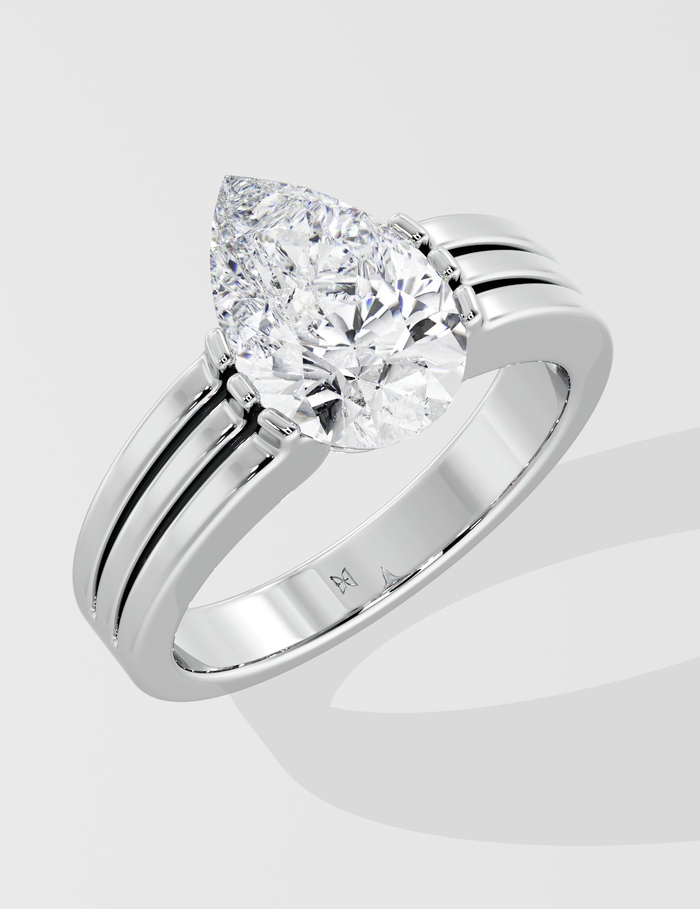 Silver pear diamond ring on a light gray background