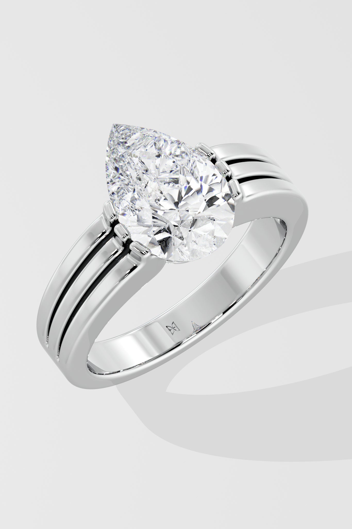 Silver pear diamond ring on a light gray background