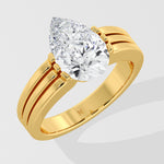Gold pear diamond ring on a light gray background