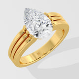Gold pear diamond ring on a light gray background