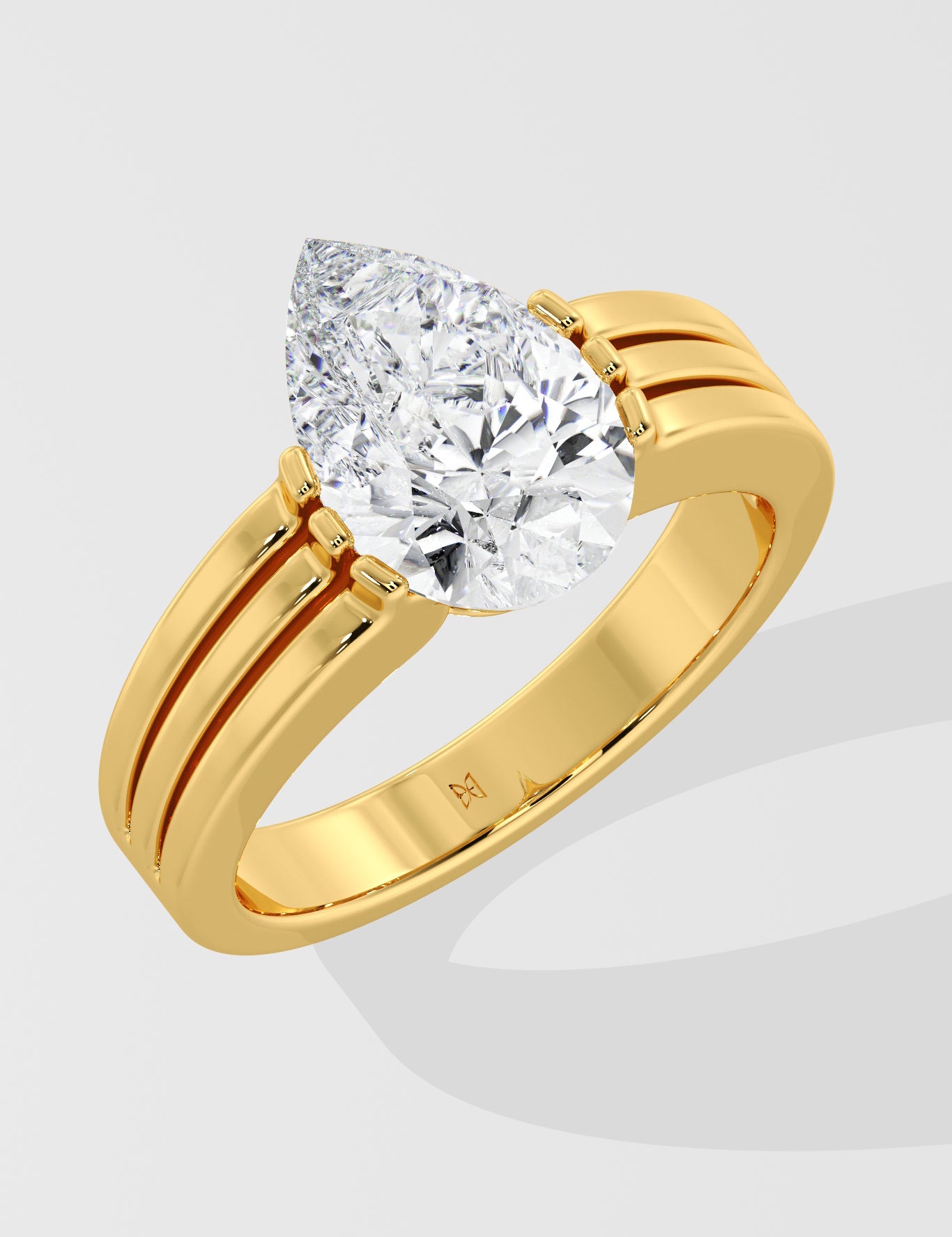Gold pear diamond ring on a light gray background