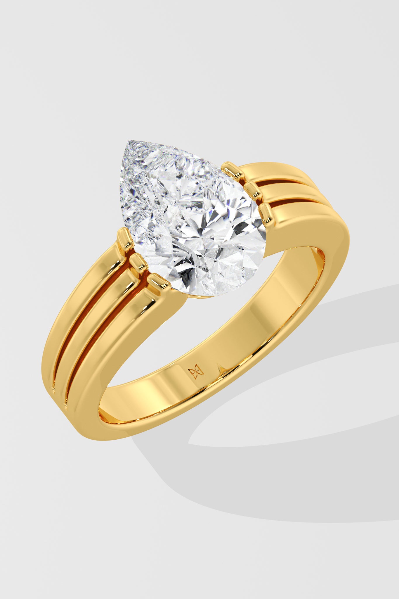 Gold pear diamond ring on a light gray background
