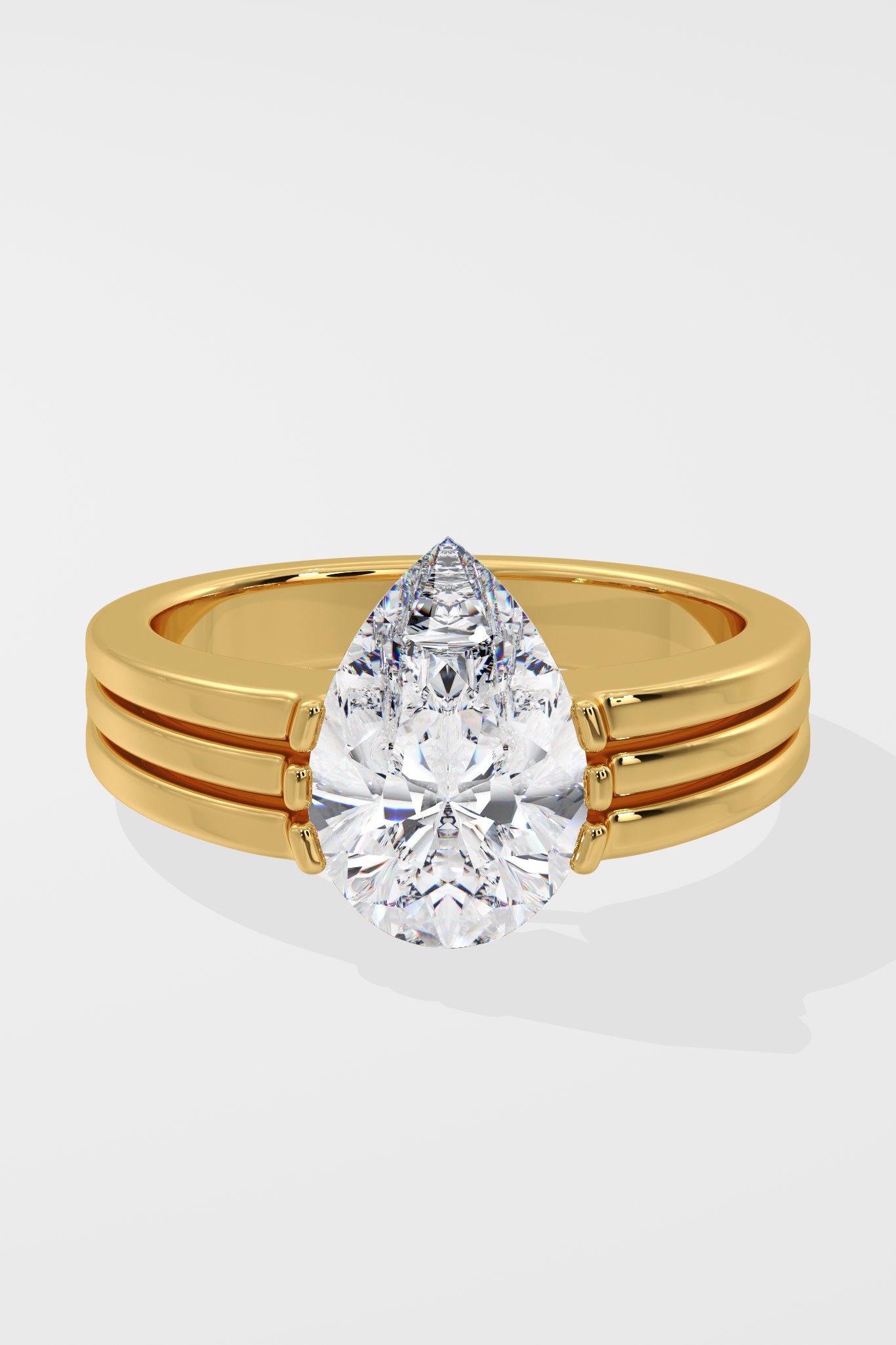 Gold pear diamond ring on a white background