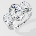 Silver three stone diamond ring on a light gray background