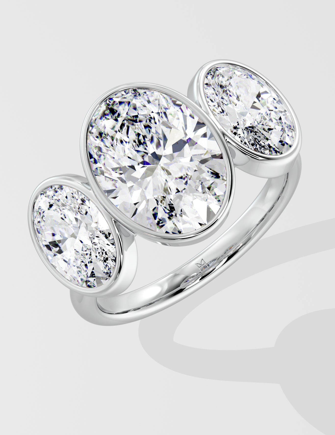 Silver three stone diamond ring on a light gray background
