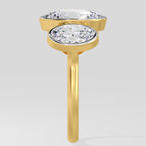 Gold ring with two diamond stones on a light gray background