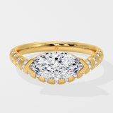 Diamond ring with a large diamond and smaller diamonds on the band against a white background