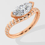 Rose gold diamond ring with a large diamond and smaller diamonds on the band against a light gray background
