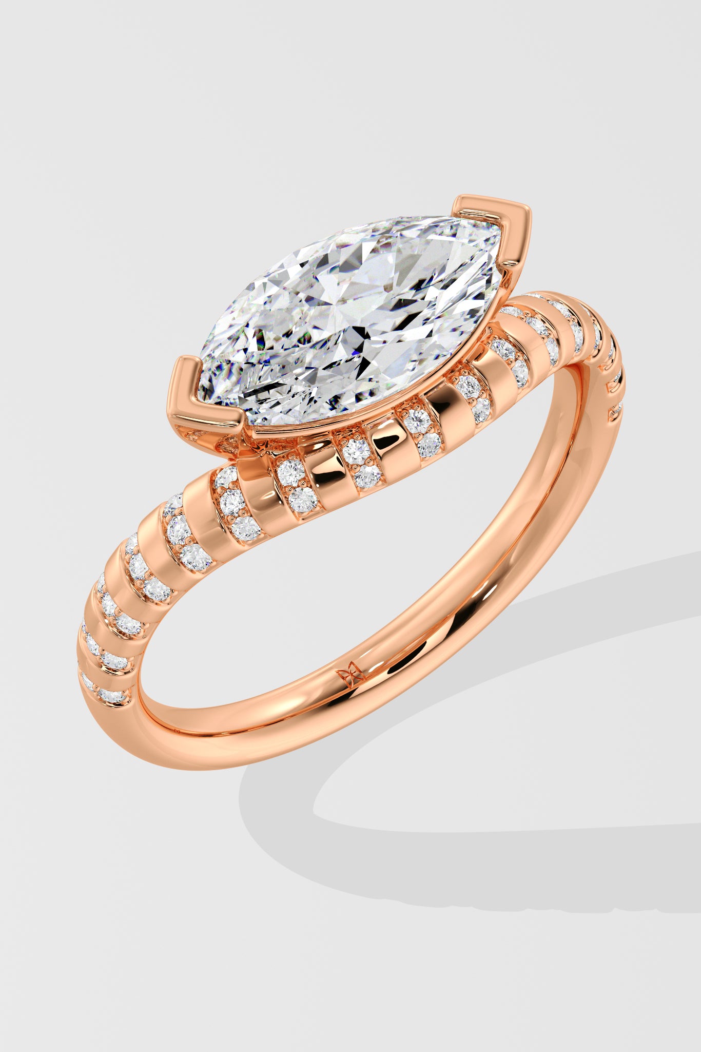 Rose gold diamond ring with a large diamond and smaller diamonds on the band against a light gray background