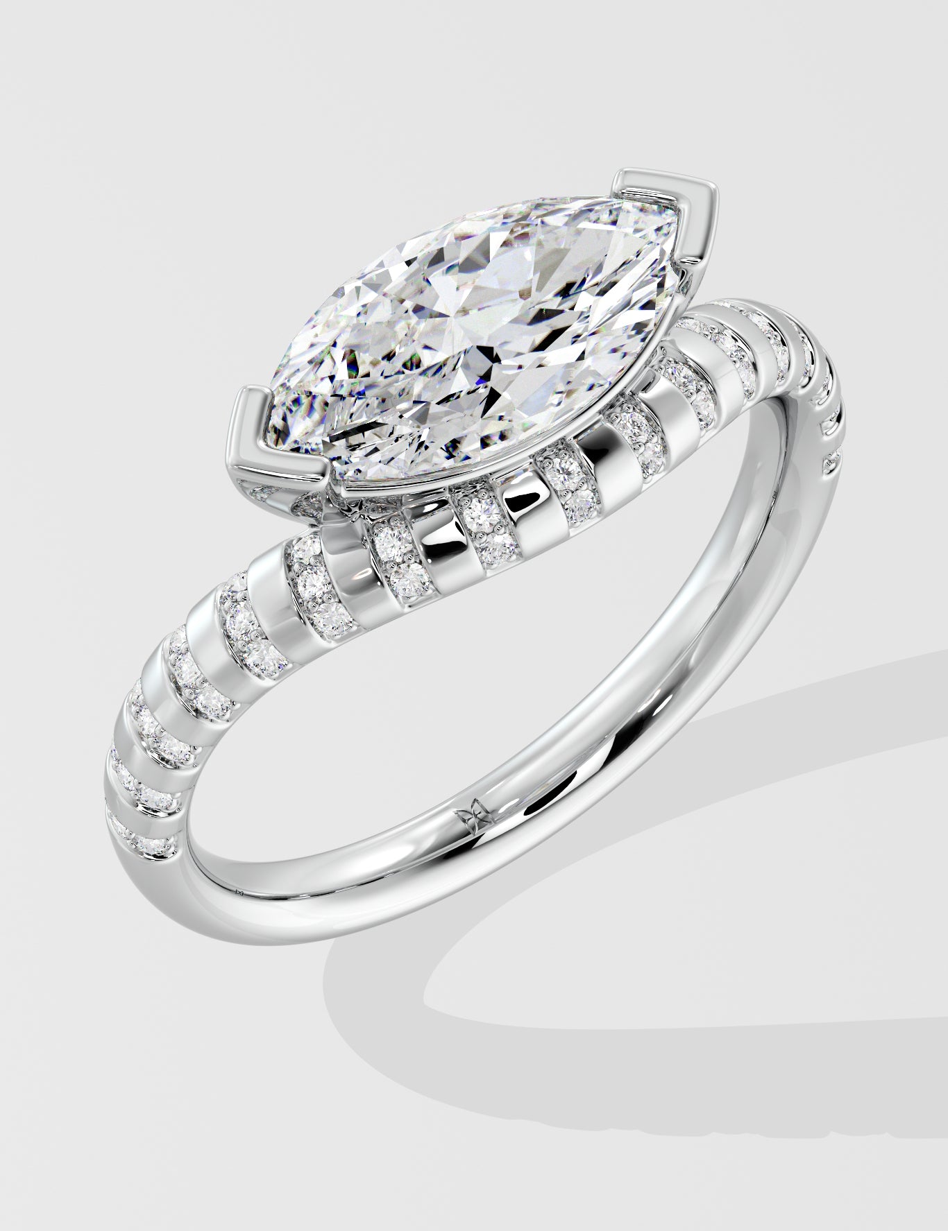 Diamond ring with a pear-shaped center stone on a light gray background