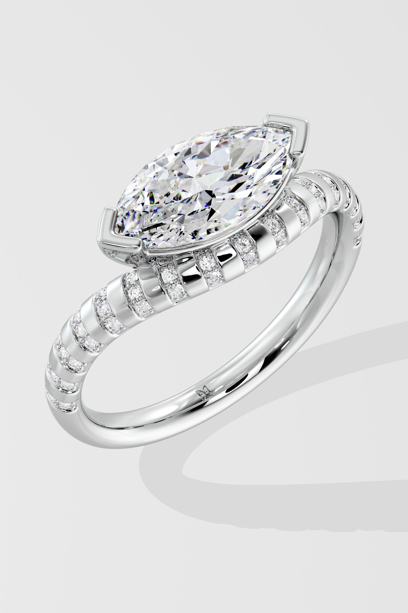 Diamond ring with a pear-shaped center stone on a light gray background