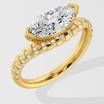 Gold diamond ring with a large pear-shaped diamond on a light gray background