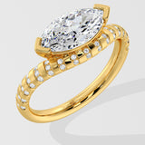 Gold diamond ring with a large pear-shaped diamond on a light gray background