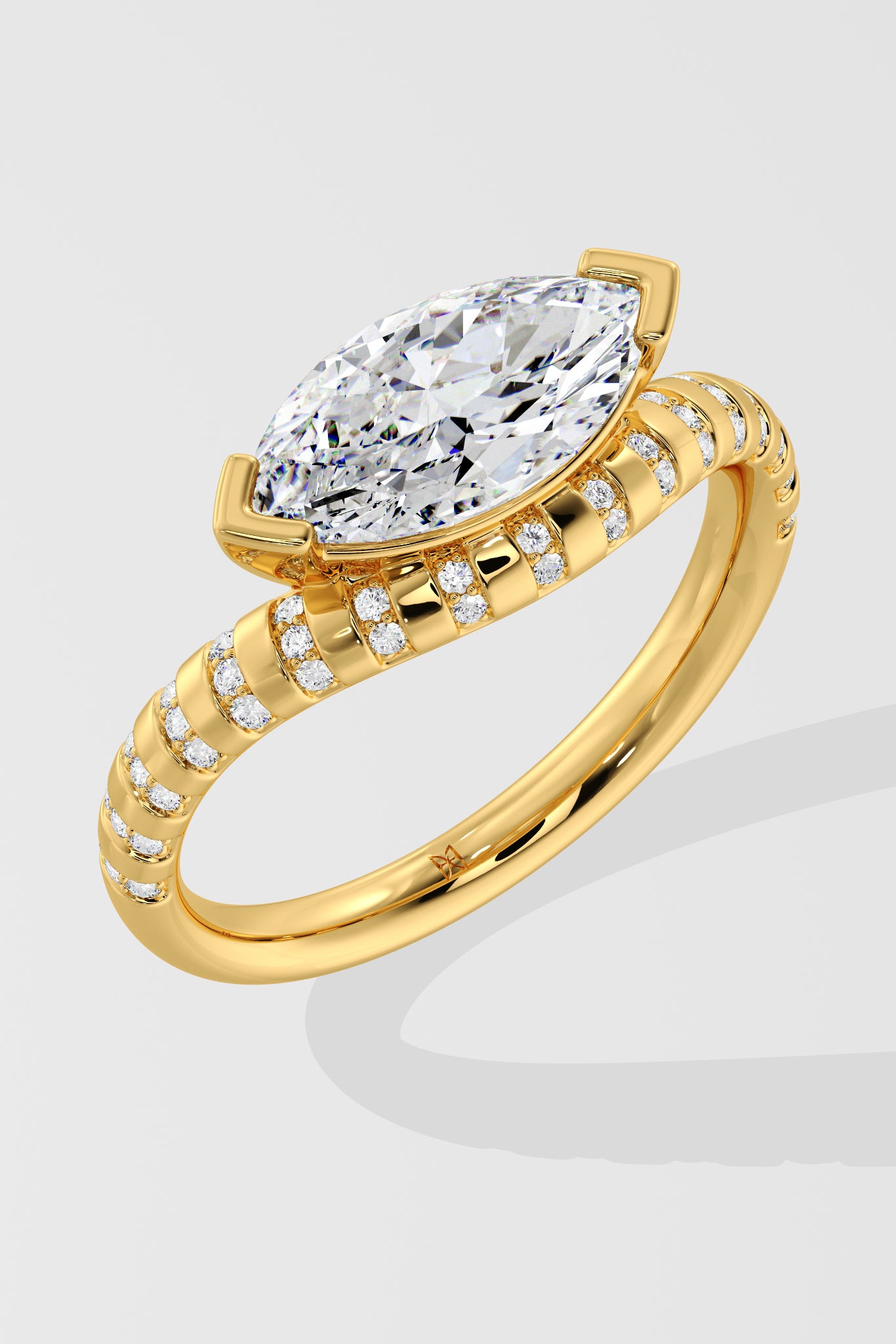 Gold diamond ring with a large pear-shaped diamond on a light gray background