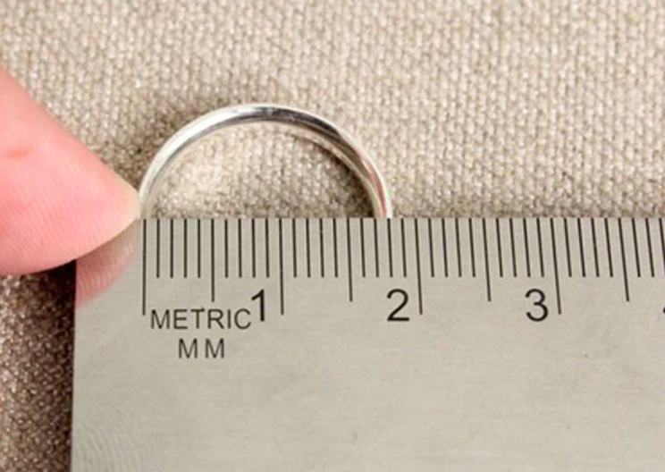 A ring placed on a millimetre ruler to measure its inner diameter.